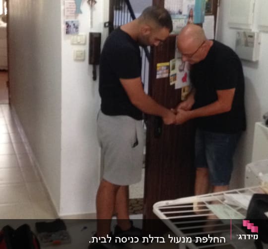שני אנשים עובדים על מנעול דלת עם כלים שונים
